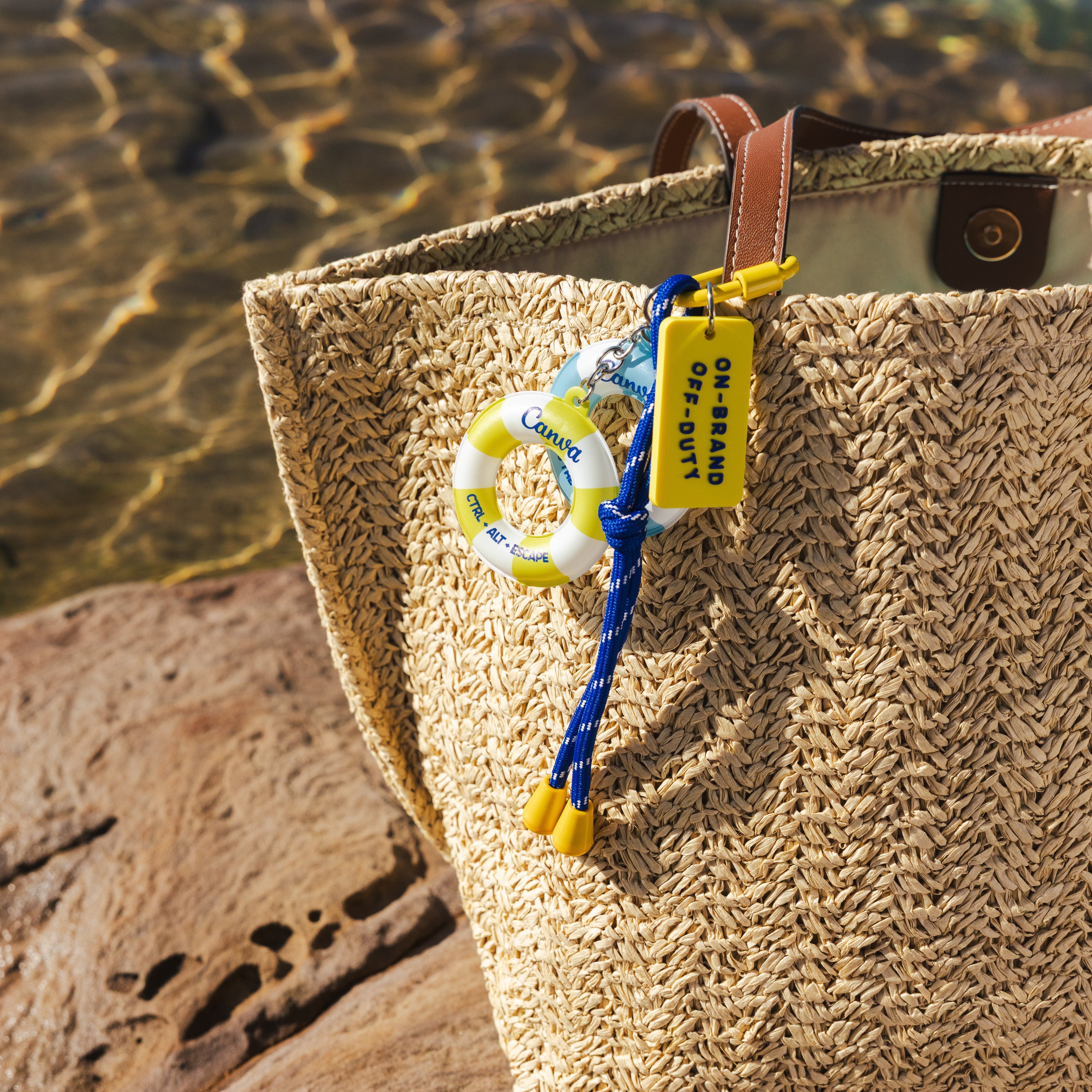 Woven bag with a keychain on a rock by the water