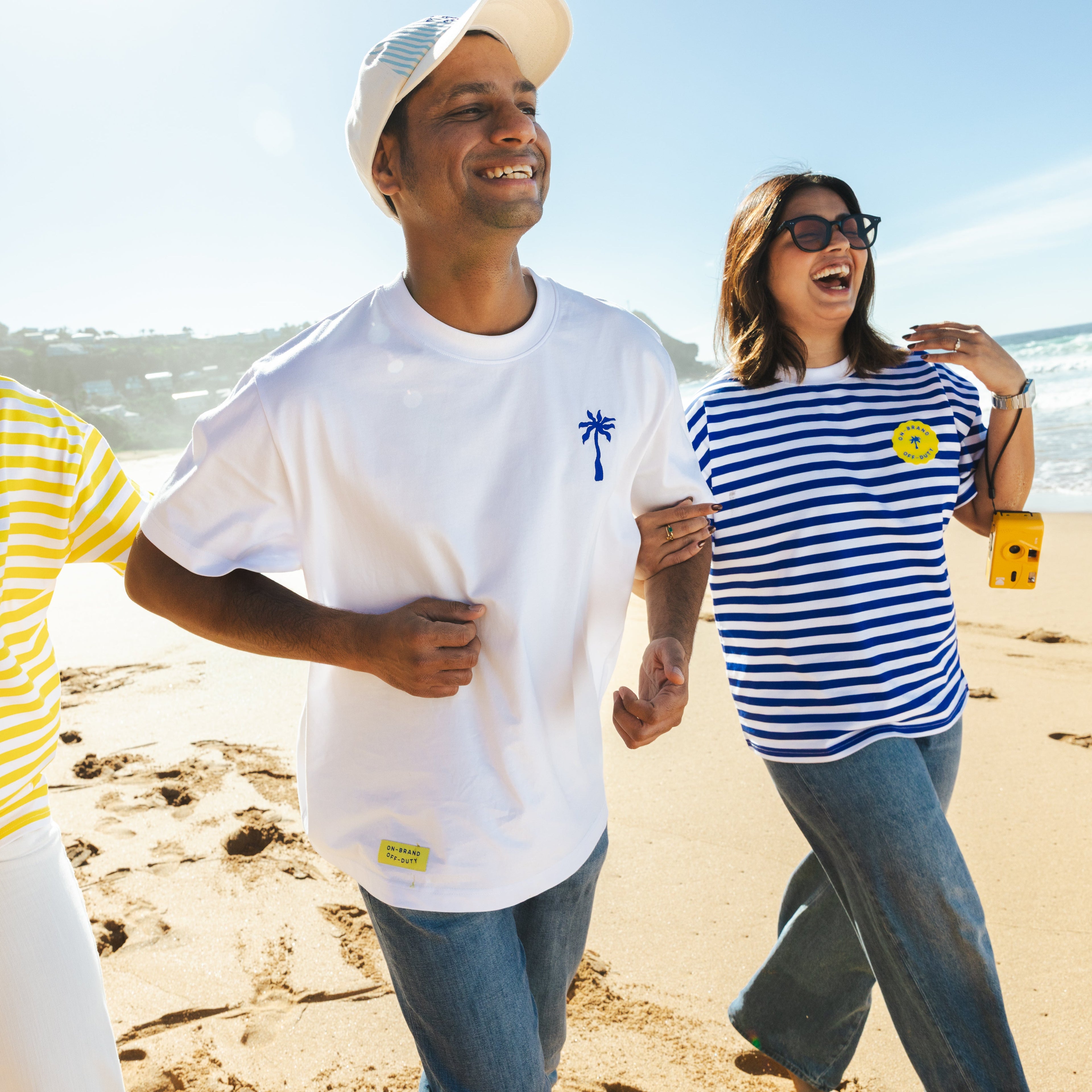 Three people walking on a beach with ocean view
