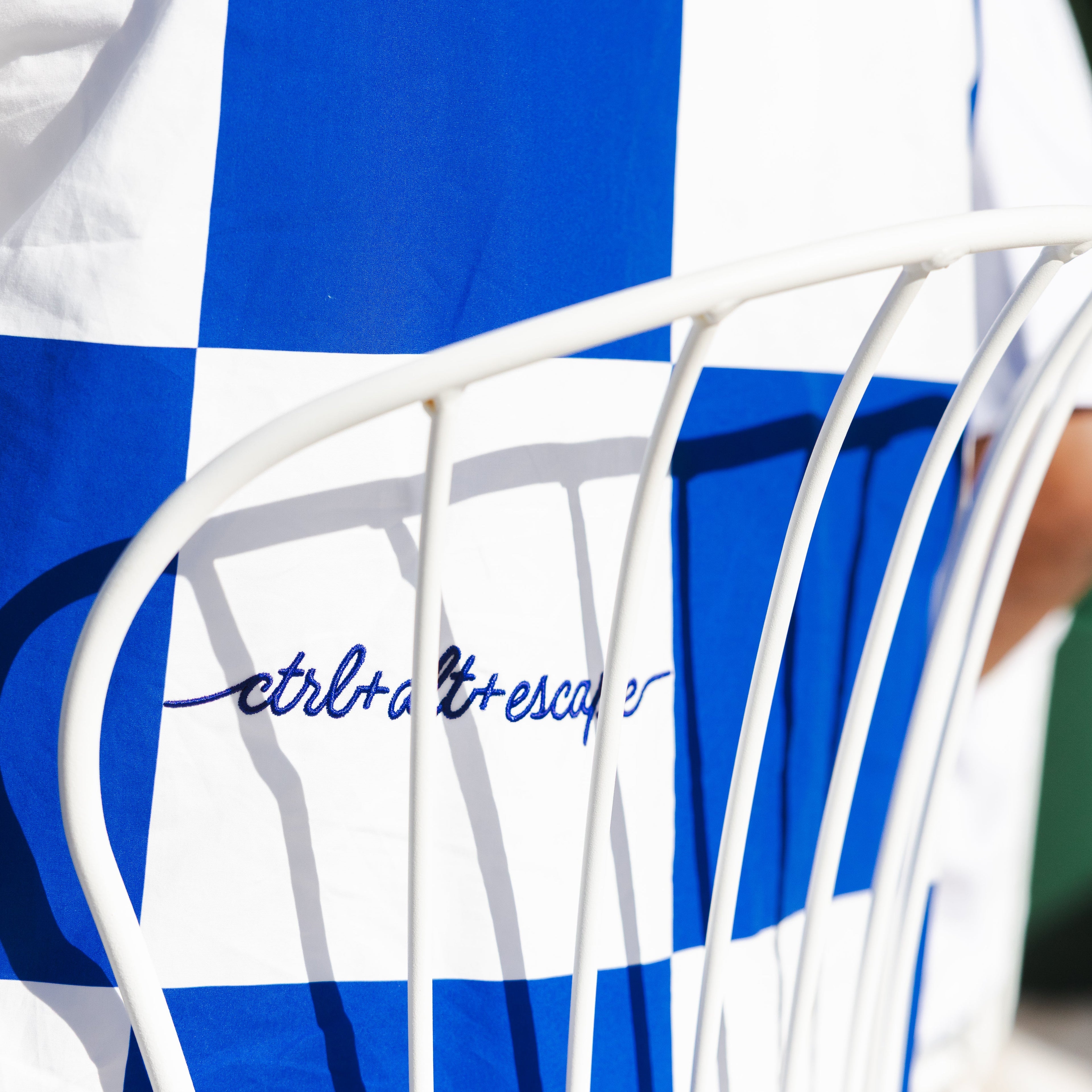 Blue and white striped towel draped over a white chair with 'Cotillion Escapes' branding.